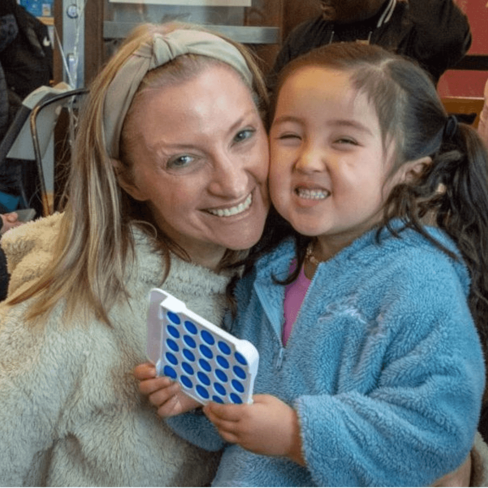 Woman and a little girl cheek-to-cheek smiling at the camera